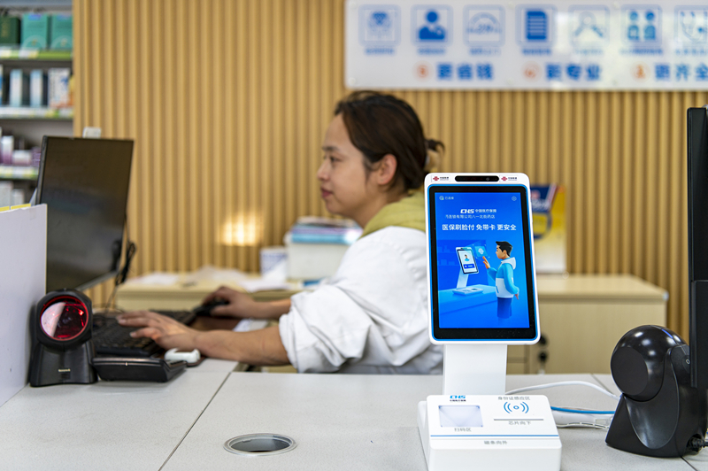 2024年4月10日，浙江金華市區(qū)一家民眾大藥房柜臺上設(shè)置著醫(yī)?！八⒛樦Ц丁睓C(jī)器，群眾看病更加便利。